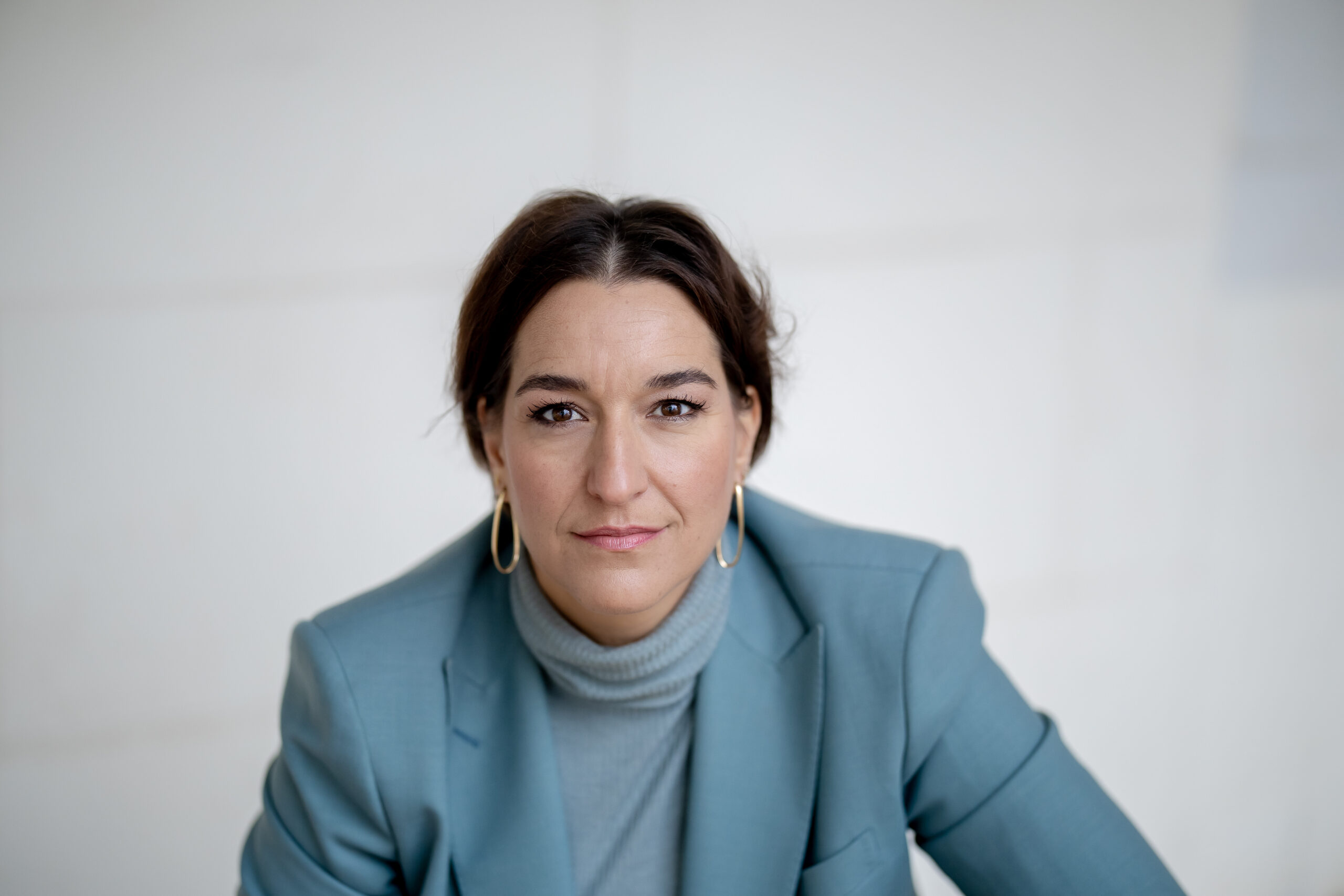 Porträt von Katinka Riemann im hellblauen Blazer mit direktem Blick in die Kamera