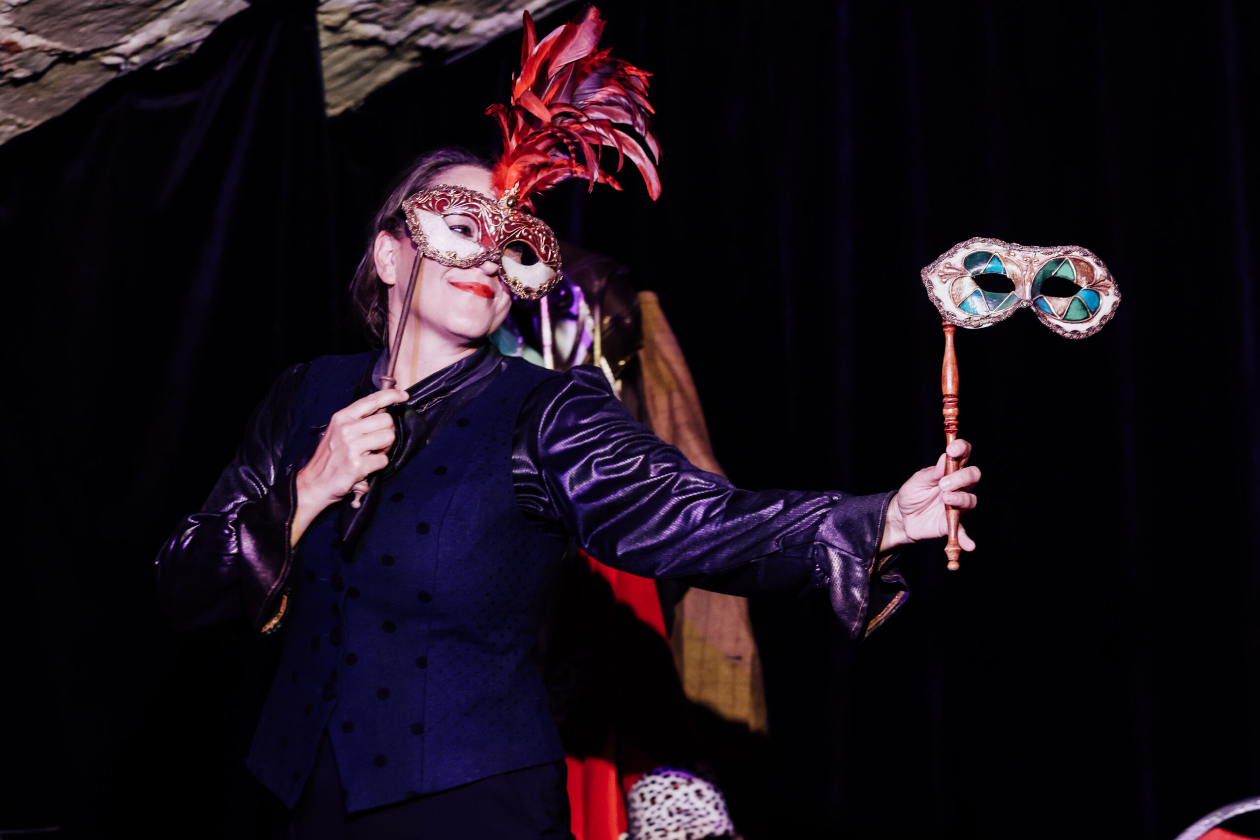 Katinka Riemann in „Froschsalat“, in jeder Hand eine venezianische Maske