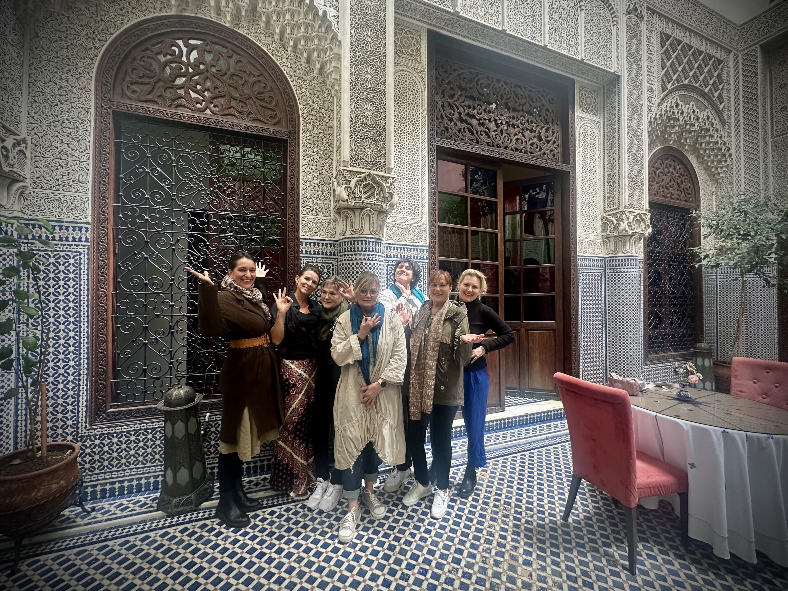 Gruppe in Kostümen posiert im gefliesten Innenhof eines Riads in Marrakesch