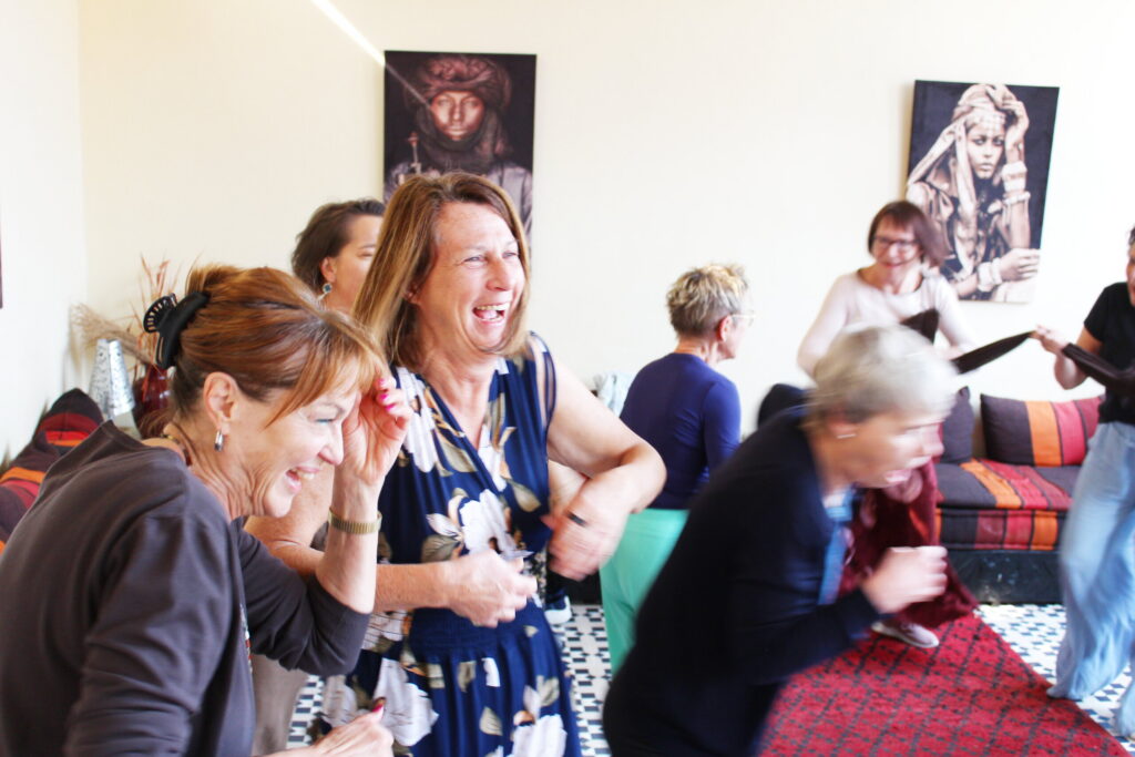 Teilnehmende lachen gemeinsam im Workshopraum