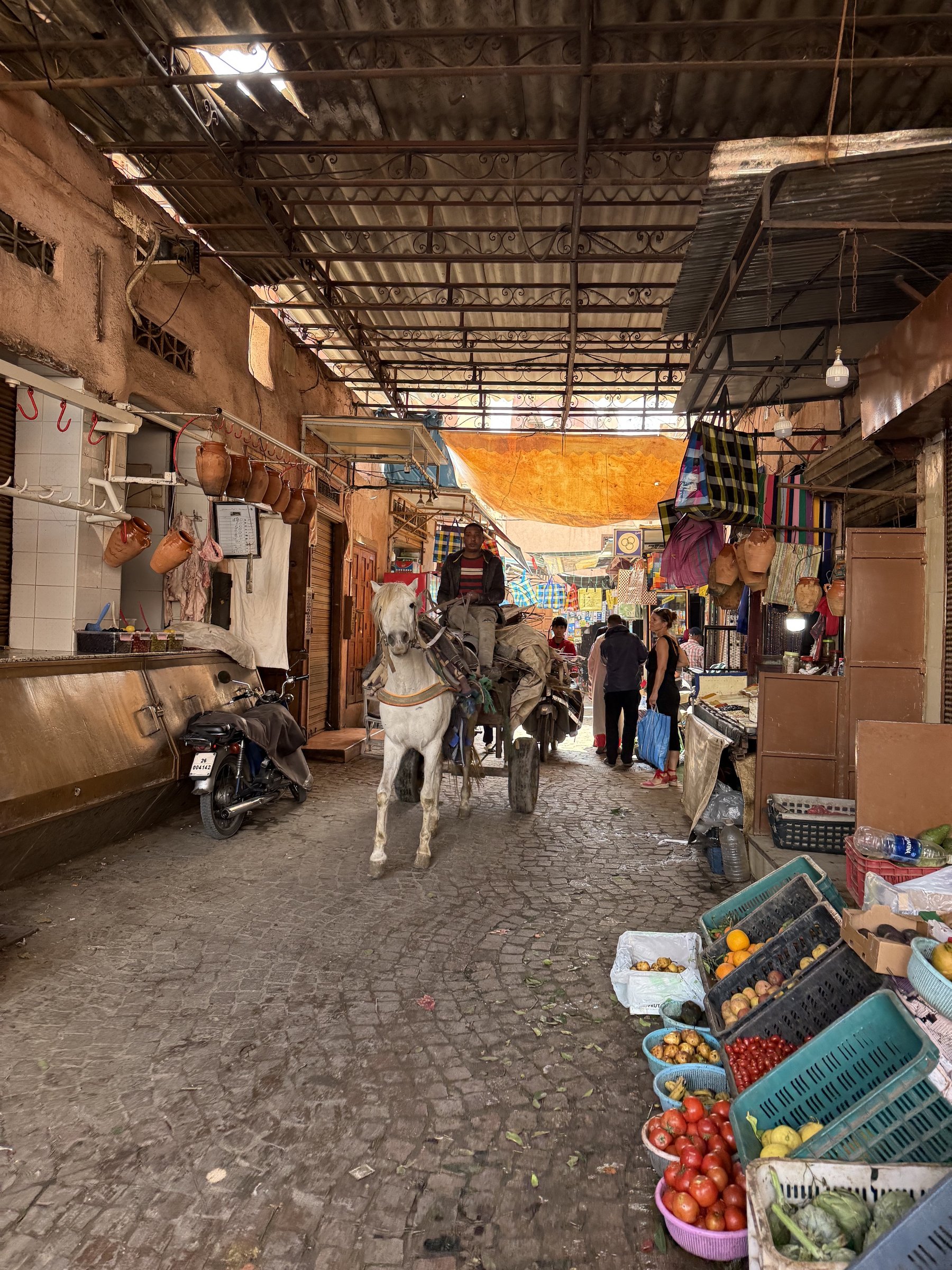Gasse im Souk von Marrakesch mit Eselskarren und Marktständen